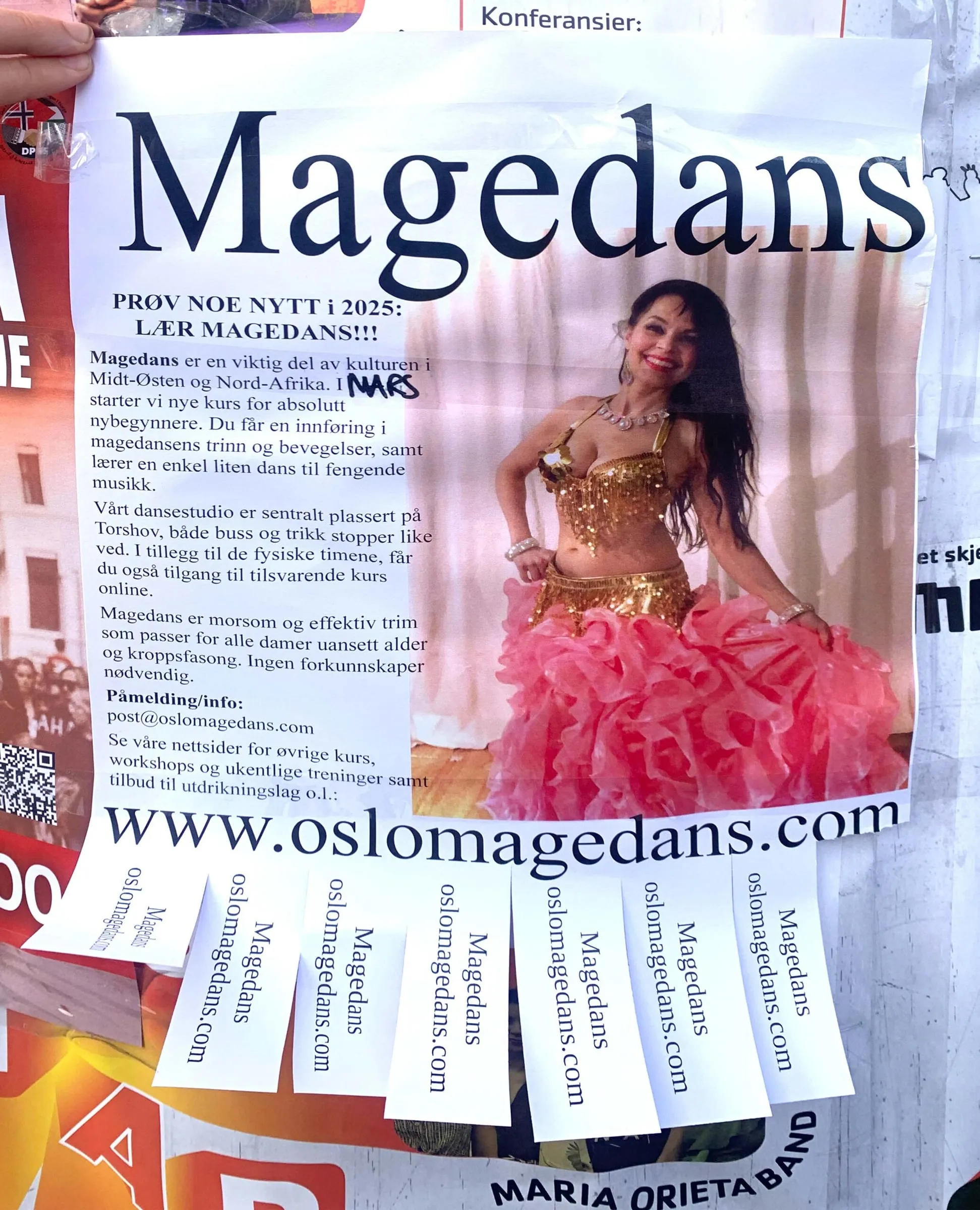 Street poster for Magedans with a belly dancer in gold and pink, and tear-off tabs